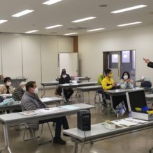 手品の種明かしを真剣に見ている参加者